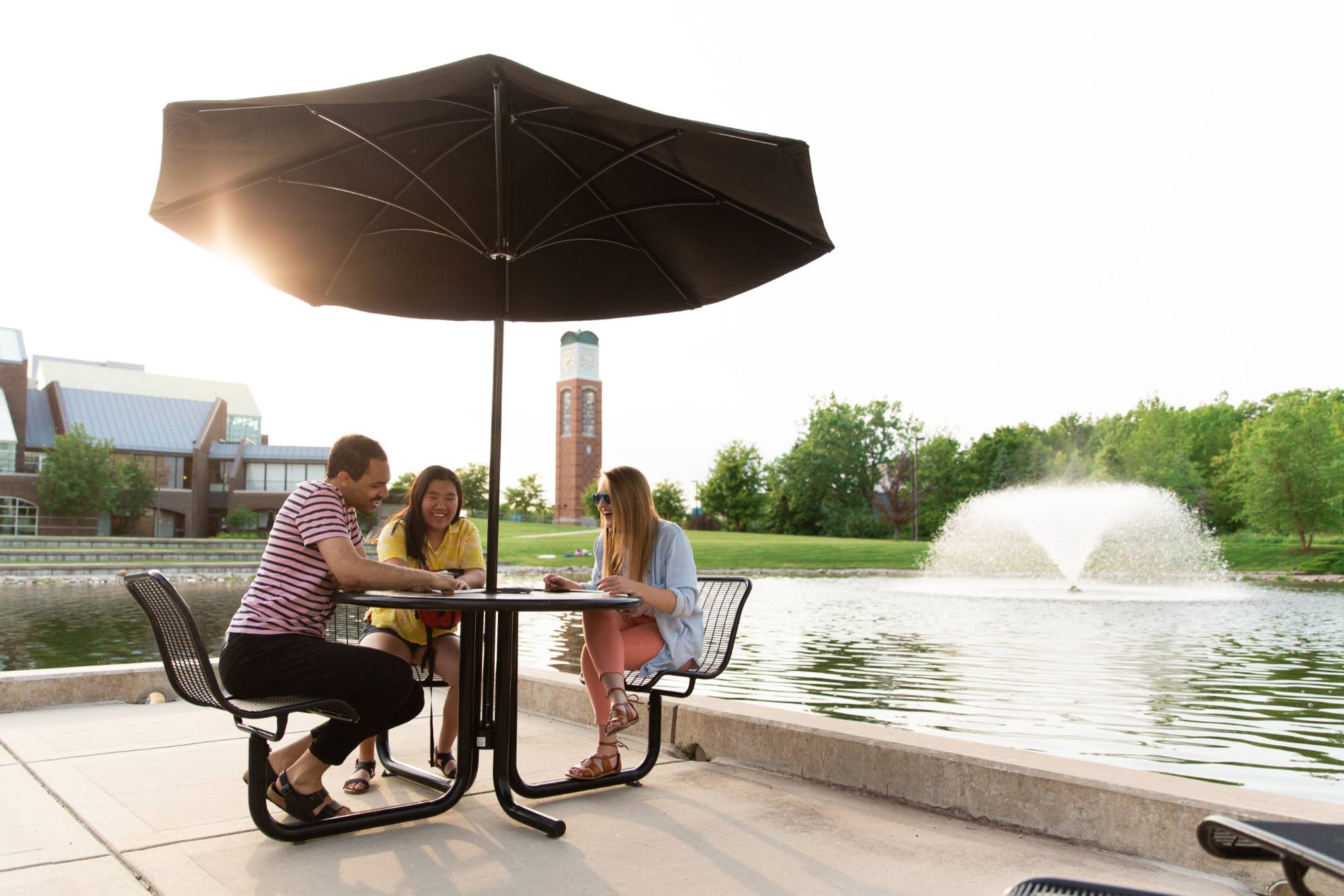 Three students studying by Zumberge Pond.